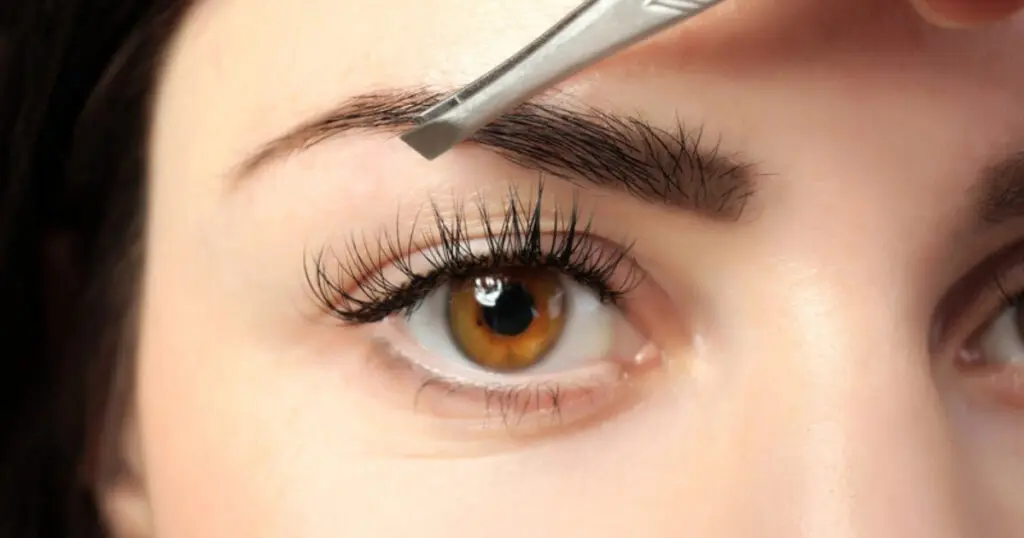 Augenbrauen zupfen mit Pinzette, Auge mit vollen Wimpern